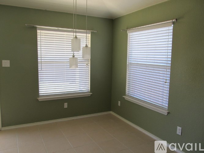 A room with two windows and a hanging light fixture.