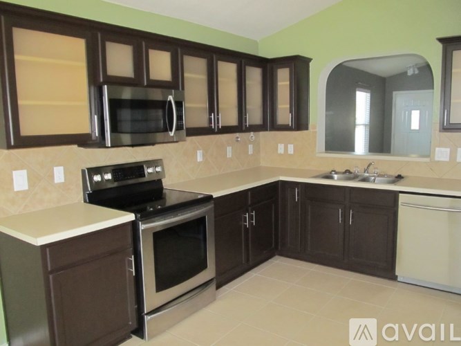 A kitchen with brown cabinets and a black stove top oven.