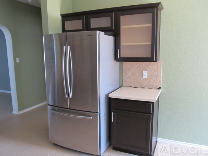 A stainless steel refrigerator with a black cabinet beside it.