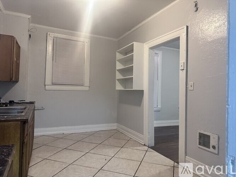 A kitchen with a sink and a window with blinds.