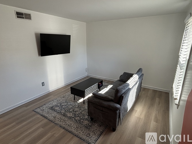 A living room with a couch, coffee table, and television.