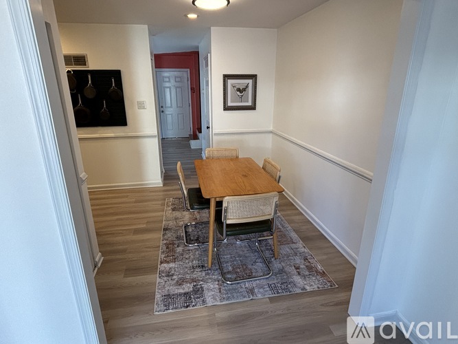 A dining room with a wooden table and chairs.