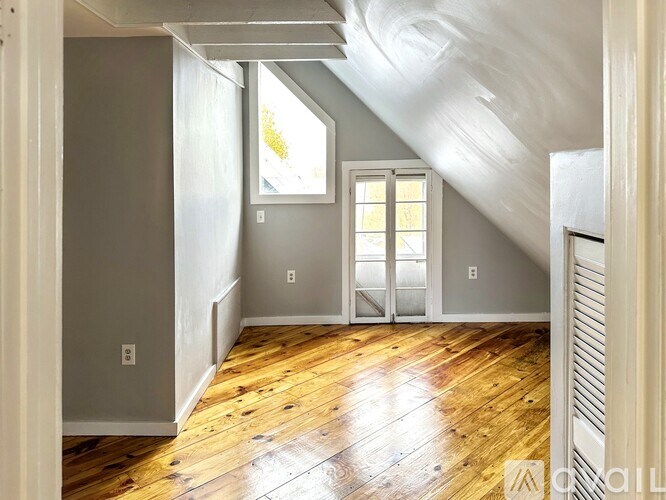 A room with wooden floors and a window.