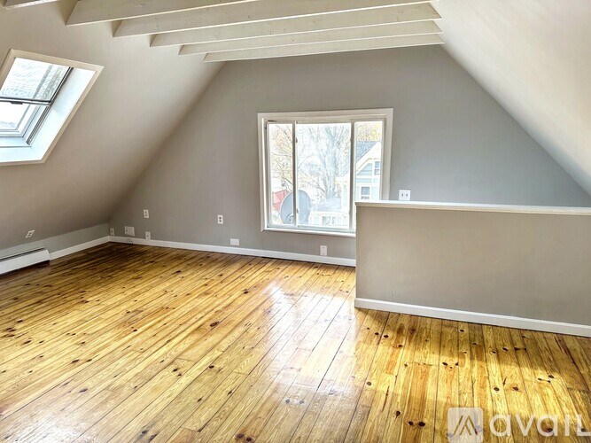 A room with wooden flooring and a window.