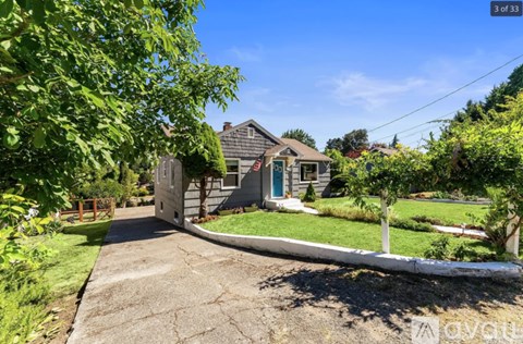 A house with a driveway and a tree in front of it.