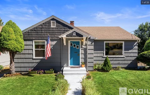 A house with a blue door and an American flag on the front porch.