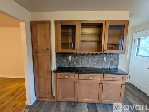 A hallway with a brown door and a white wall.