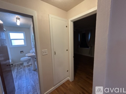 A small bathroom with a toilet, sink, and window.