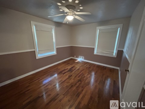 A room with wooden floors and a ceiling fan.