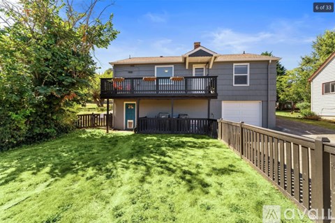 A house with a balcony and a green lawn.