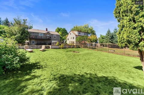 A backyard with a fence and a house in the background.