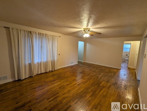 A room with wooden flooring and a ceiling fan.