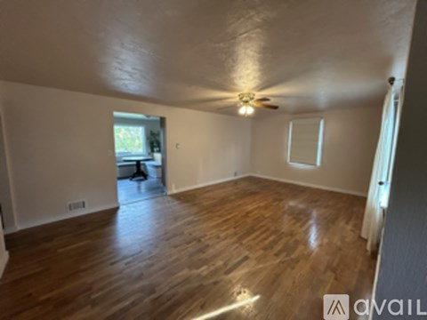 A room with wooden floors and a ceiling fan.