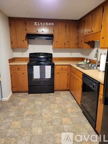 A kitchen with wooden cabinets and a black stove top oven.