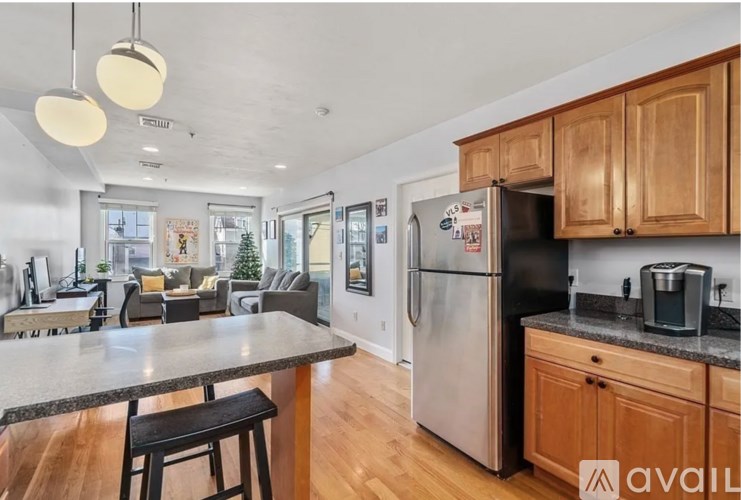 A kitchen with a black fridge and wooden cabinets.