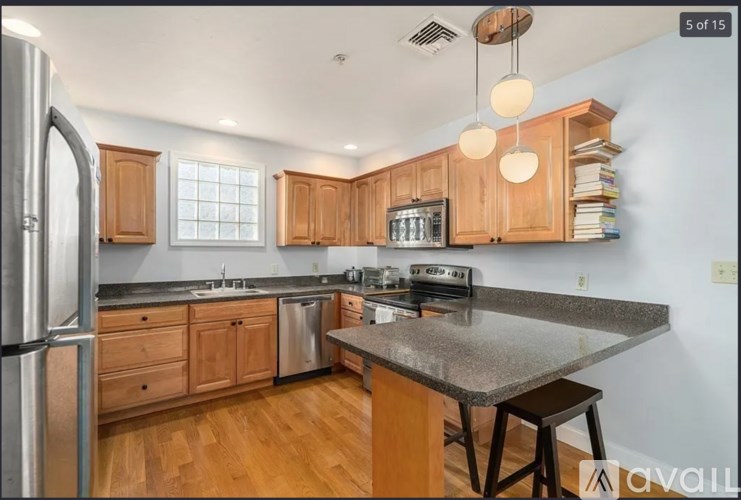 A kitchen with wooden cabinets and a granite countertop.