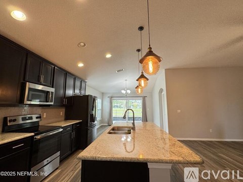 A kitchen with black cabinets and a granite countertop.
