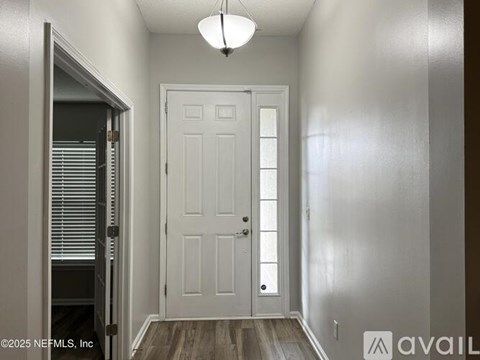 A white door is in the middle of a hallway.