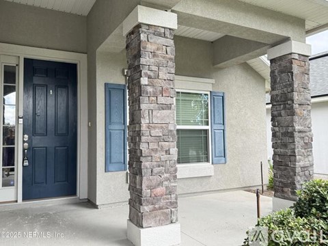 A house with a blue door and a window with blinds.