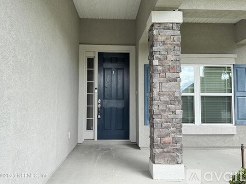 A house with a dark blue door and a stone pillar.