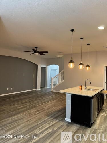 A kitchen with a white countertop and a ceiling fan.