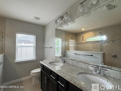 A bathroom with a sink, toilet, and mirror.