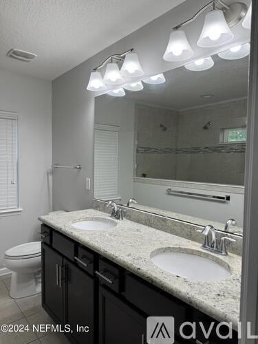 A bathroom with a marble countertop and a large mirror.