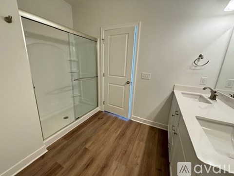 A bathroom with a glass shower door and a white sink vanity.