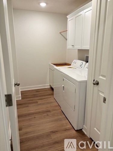 A white kitchen with wooden floors and white cabinets.