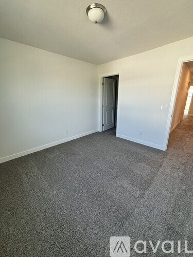A room with grey carpet and a closed door.