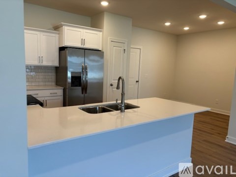 A kitchen with a stainless steel refrigerator and a white countertop.
