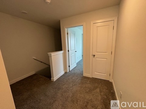 A carpeted room with a door and a window.