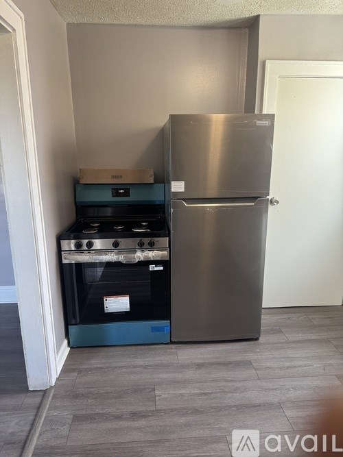 A kitchen with a stainless steel refrigerator and a black oven.