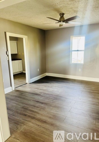 A room with a ceiling fan and a window.