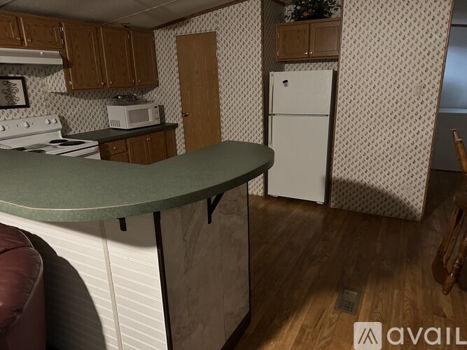 A kitchen with a white refrigerator and a green counter.