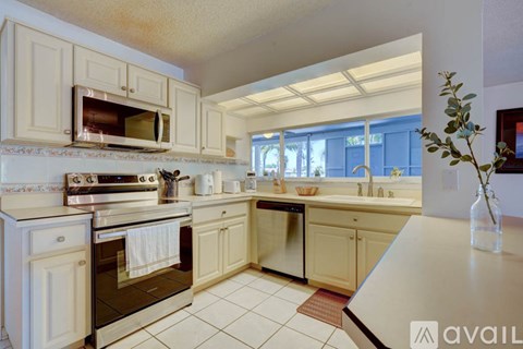 A kitchen with white cabinets and appliances.