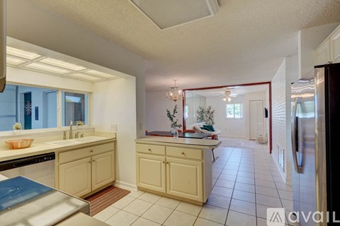 A kitchen with white cabinets and a stainless steel refrigerator.