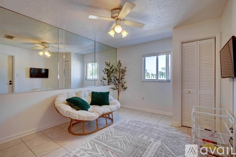 A living room with a white couch and a mirror on the wall.