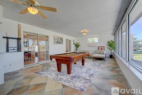 A room with a pool table and a fan.
