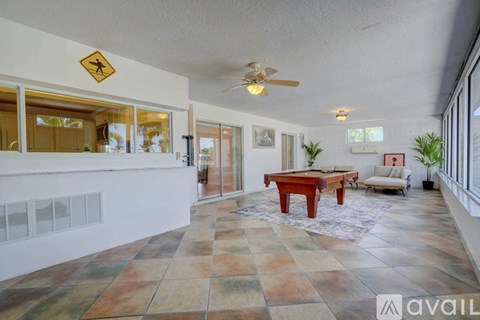A room with a pool table and a ceiling fan.