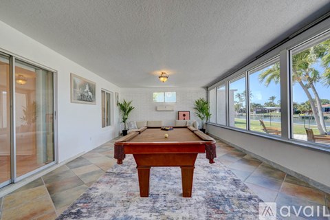 A room with a pool table and a view of the outside.