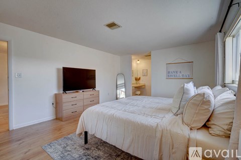 A bedroom with a bed, dresser, and mirror.