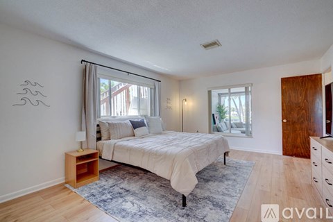 A bedroom with a bed, nightstand, and window.