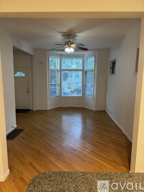 A room with a ceiling fan and a rug on the floor.