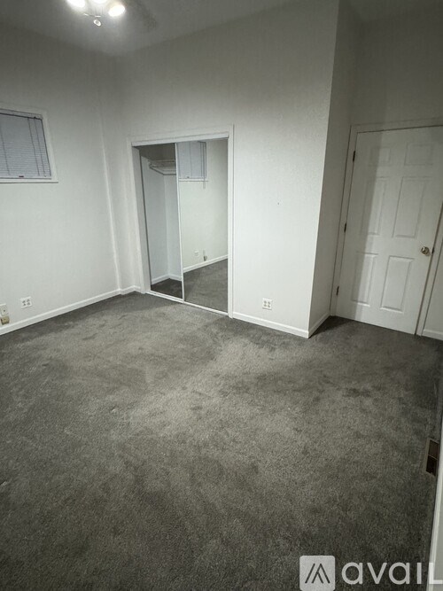 A room with a grey carpet and a white door.