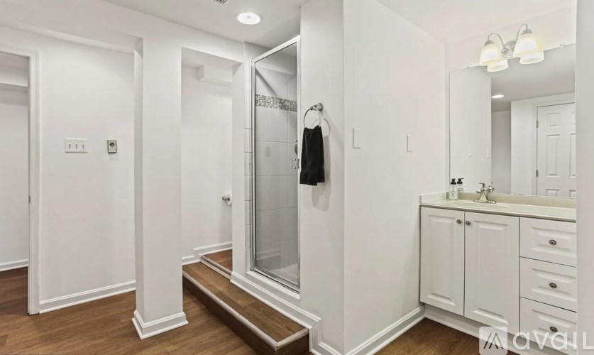 A bathroom with a white door, a white sink, and a white cabinet.