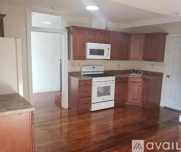 A kitchen with brown cabinets and white appliances.