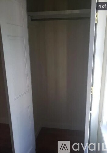 A white door is open to a dark room.