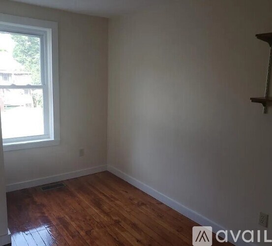 A room with wooden floors and a window.