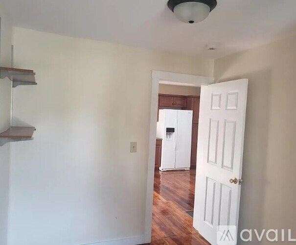 A room with a white door and a white wall.